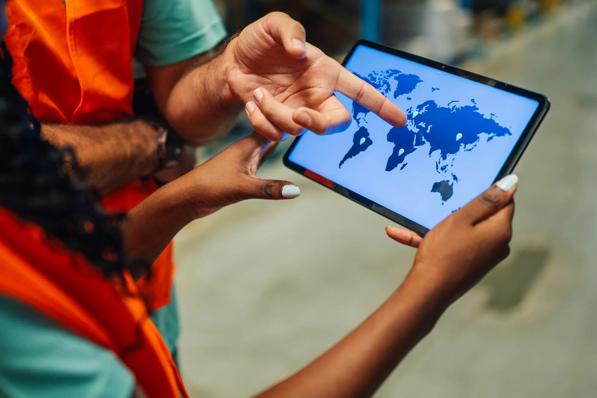 Sourcing team planning global supply chains on a tablet map at a garment buying house in India