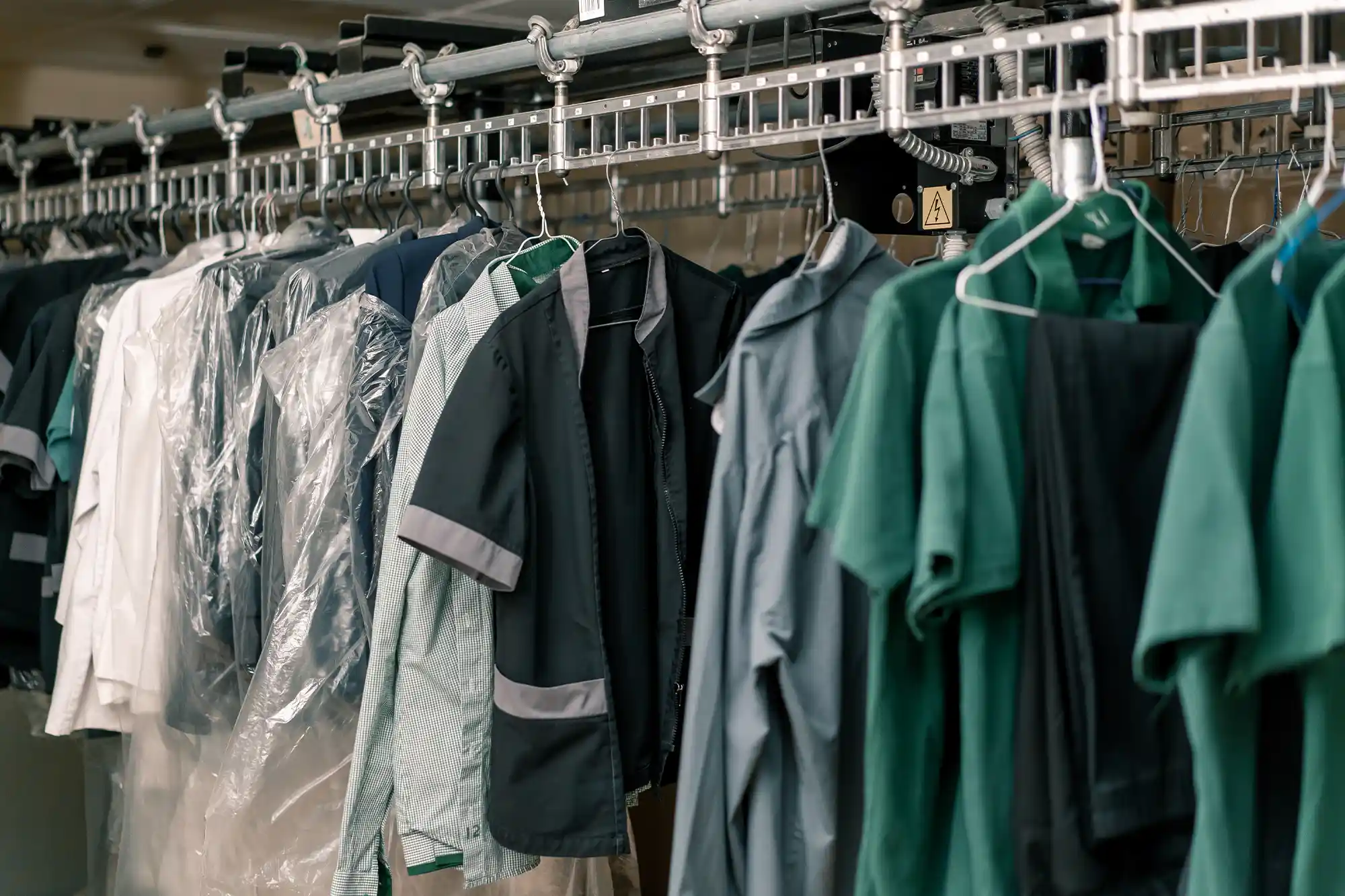Corporate uniforms and workwear on hangers in a garment factory in India